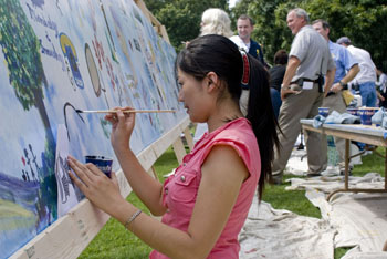 Ding Yu gets creative with the mural on Library Lawn. (photo by Susan Urmy)