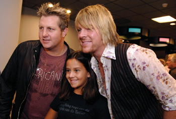 Rascal Flatts members Gary LeVox, left, and Joe Don Rooney, right, pose for a photo with Annalise Perry.