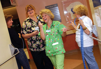 Mary Martens, R.N., second from left, and Holly Gramins, R.N., laugh as they receive their door prize tickets from Susie Lyons, left, and Jane Tugurian, right, as they enter the Night Owl Howl, an Employee Celebration Month party specifically planned for night-shift workers.
photo by Dana Johnson
