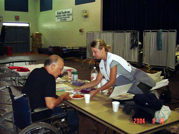 Kelly Kron serves Red Cross Shelter client, Santos, dinner. 