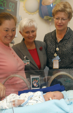 Patricia Temple, M.D., center, and Melanie Lutenbacher, Ph.D., right, visit with Kristy Gott and her son, Will, in the NICU.
Photo by Susan Urmy