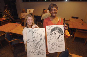 Kristi Gerard, left, and Alison Haymen model their caricature portraits.
Photo by Anne Rayner