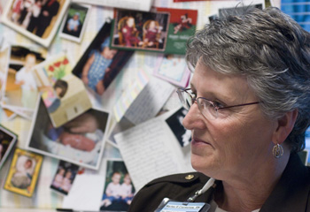 Marlee Crankshaw, R.N., in front of a board of patient photos and thank you notes in the Neonatal Intensive Care Unit. (photo by Dana Johnson)