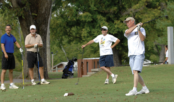 Ronald Sullivan tees off as teammates Robert West, Wayne Gatten, and Charles Risley, all of Plant Ops, wait their turn. (photo by Neil Brake)