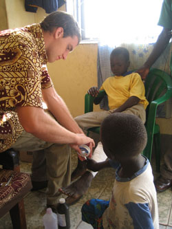 VUSM student Matt Kynes tapes a child’s leg at the Cornerstone Children’s Home in Nimule, Sudan.