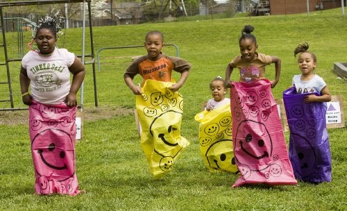 From left, Victoria Moore, Donovan Manning, Ariana Ricketts, Nia Ricketts and Mya Ricketts compete in a sack race during the Veggie Fair. The event was held for children of the community to promote healthy eating. (Photo by Dana Johnson)
